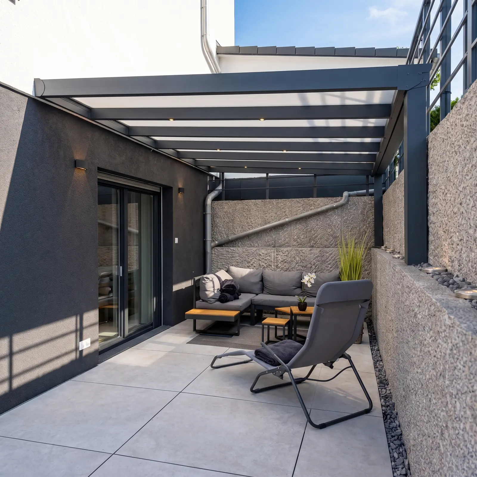 Überdachte Terrasse mit Lounge und Liegestuhl