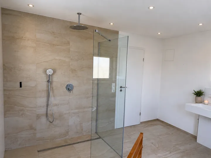 Bodenebene Dusche mit Glaswand und Regenbrause